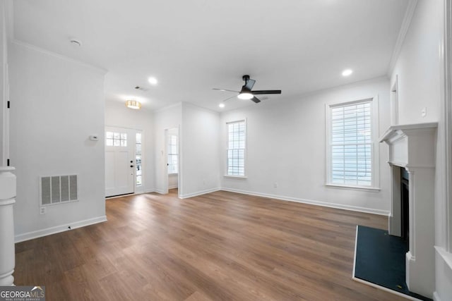 unfurnished living room featuring hardwood / wood-style flooring, ornamental molding, and ceiling fan