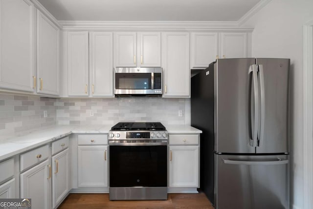 kitchen featuring tasteful backsplash, light stone countertops, white cabinets, and appliances with stainless steel finishes