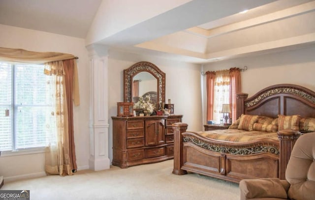 carpeted bedroom with vaulted ceiling, decorative columns, and a raised ceiling