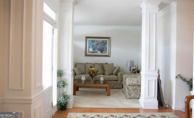 sitting room featuring ornate columns, ornamental molding, and a wealth of natural light