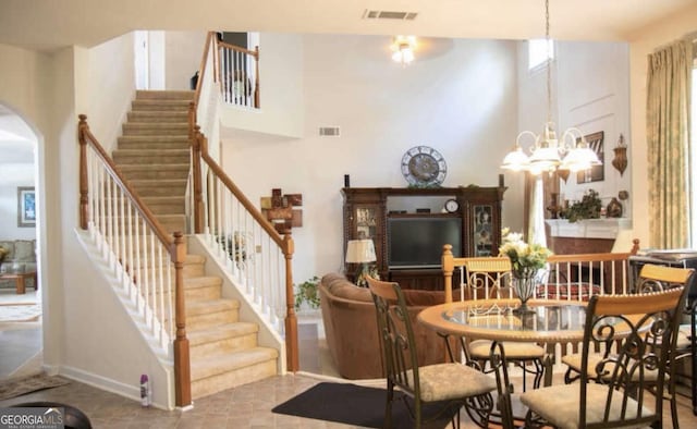 dining area featuring an inviting chandelier and a high ceiling