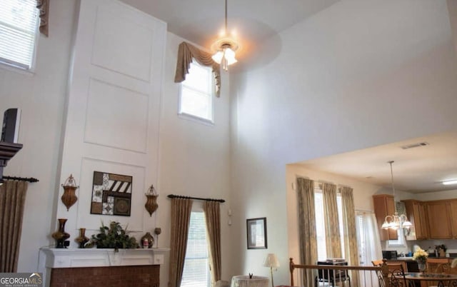 interior space featuring a healthy amount of sunlight, a chandelier, and a high ceiling