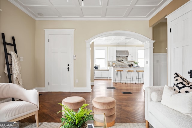 living room with arched walkways, baseboards, ornate columns, and wood finished floors