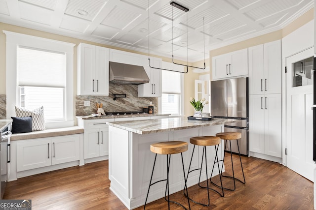 kitchen featuring range hood, a center island, dark wood-type flooring, and stainless steel appliances