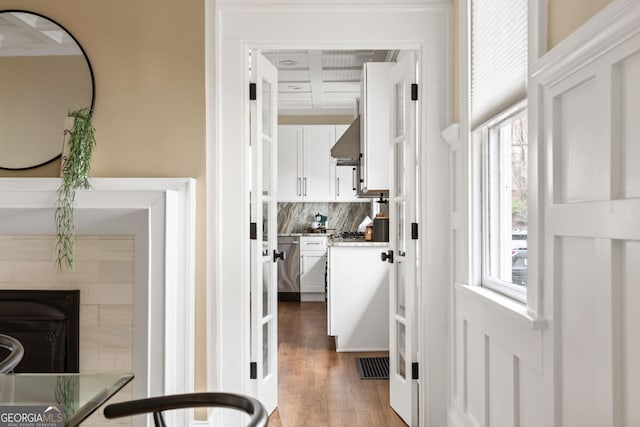 hallway with wood finished floors and visible vents