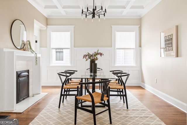 dining area with beamed ceiling, coffered ceiling, and wood finished floors