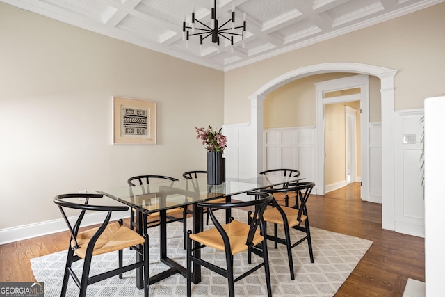 dining room featuring beam ceiling, wood finished floors, and arched walkways