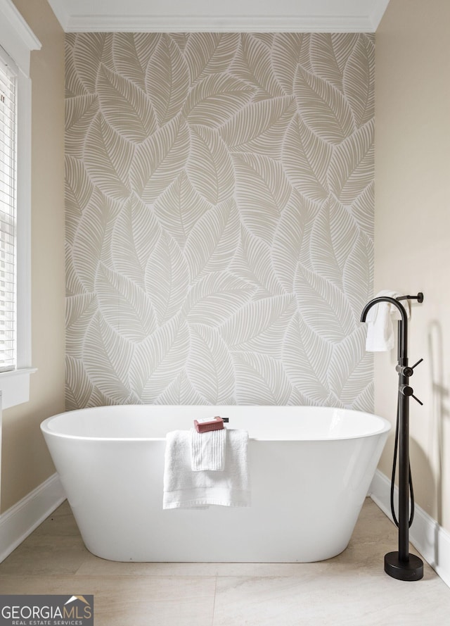 bathroom featuring a soaking tub, baseboards, and wood finished floors