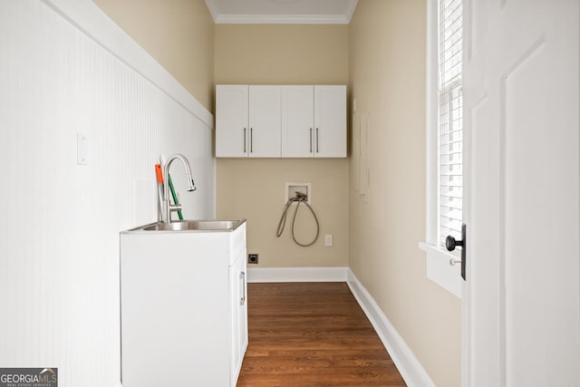 washroom with dark wood finished floors, hookup for a washing machine, cabinet space, hookup for an electric dryer, and a sink