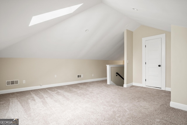 bonus room featuring vaulted ceiling with skylight, carpet flooring, baseboards, and visible vents