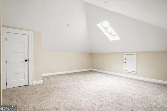 additional living space with vaulted ceiling with skylight, carpet, and baseboards