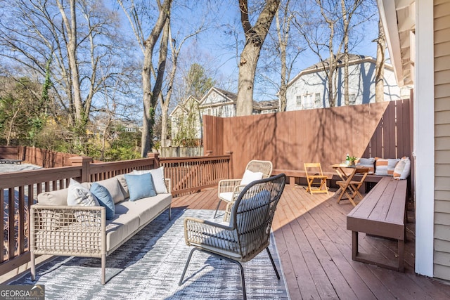 deck with an outdoor living space and fence