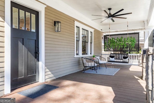 wooden deck with a porch and a ceiling fan