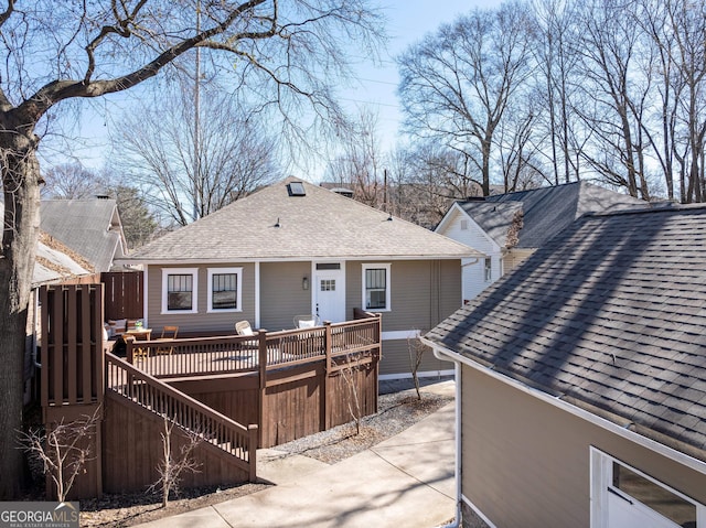 back of property featuring a deck and roof with shingles