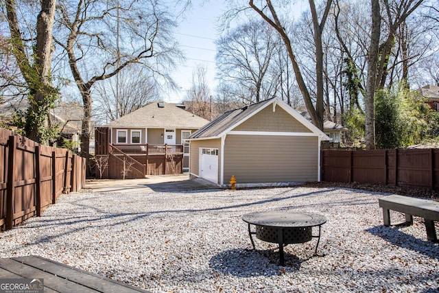 back of house featuring an outdoor structure, a fenced backyard, and a detached garage