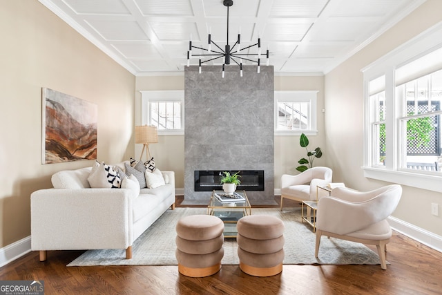 living area with wood finished floors, crown molding, a fireplace, and baseboards