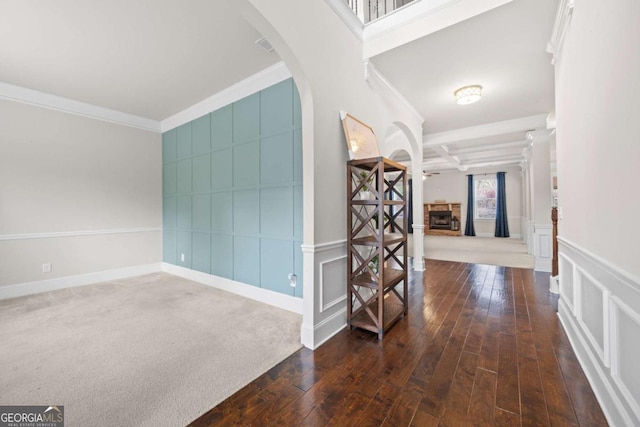 hallway featuring coffered ceiling, crown molding, dark wood-type flooring, and beamed ceiling