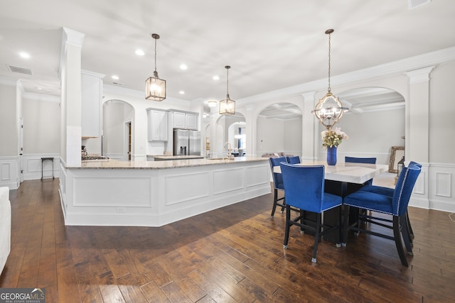 kitchen featuring white cabinetry, hanging light fixtures, light stone countertops, and stainless steel refrigerator with ice dispenser