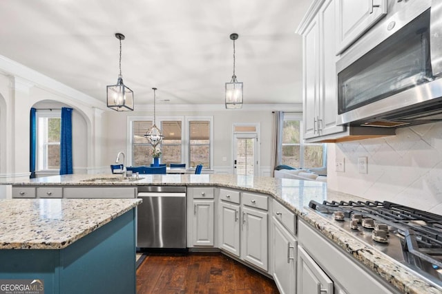 2268 Austin Common Way, Dacula, GA 30019 - kitchen featuring arched walkways, a peninsula, appliances with stainless steel finishes, a sink, and dark wood-style floors