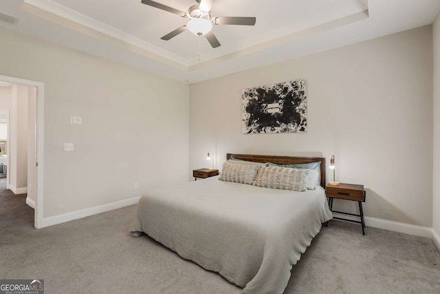 bedroom featuring light colored carpet, ceiling fan, and a tray ceiling