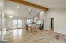 kitchen featuring beamed ceiling and a kitchen island