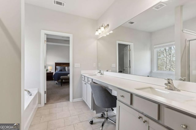 bathroom featuring vanity, tile patterned floors, and a tub to relax in