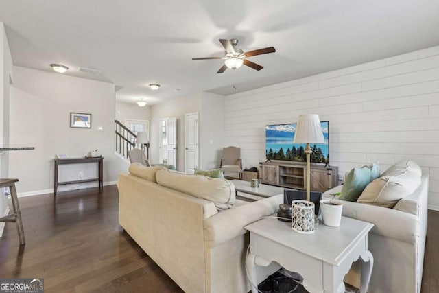 living room featuring ceiling fan and dark hardwood / wood-style floors