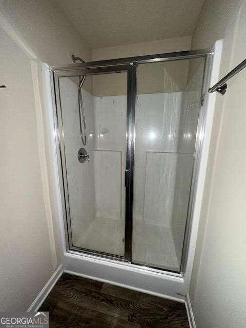 bathroom featuring hardwood / wood-style floors and walk in shower