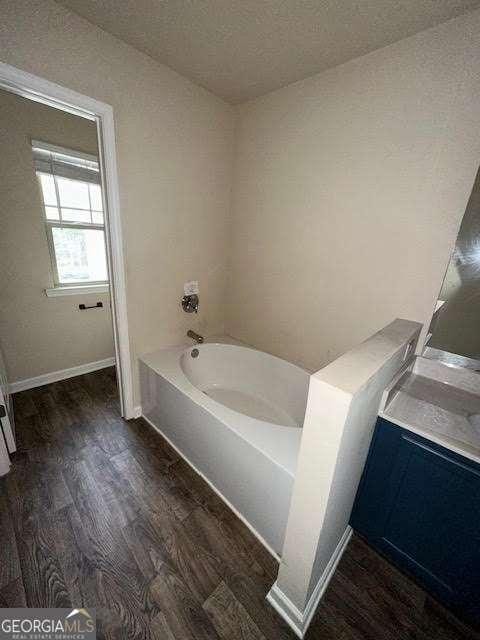 bathroom featuring hardwood / wood-style flooring, vanity, and a bathtub