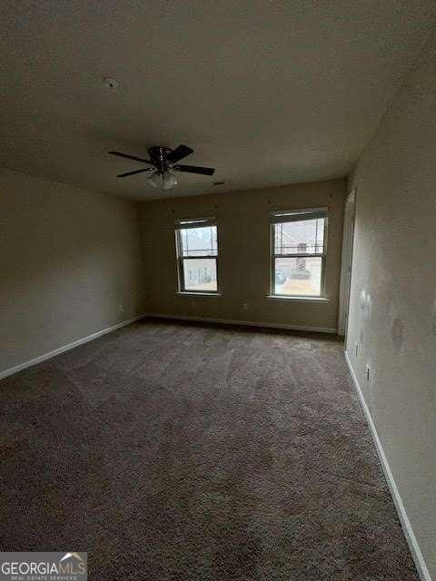 carpeted spare room with ceiling fan