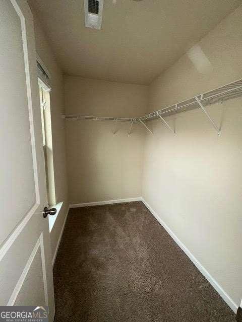 spacious closet featuring dark carpet