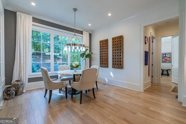 dining area featuring a healthy amount of sunlight, ornamental molding, and light hardwood / wood-style floors