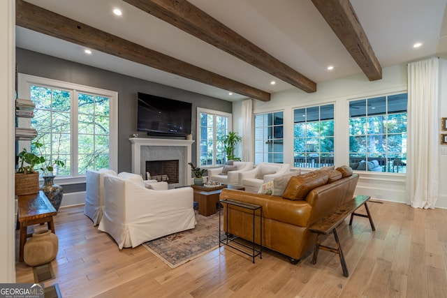 living room with beamed ceiling and light wood-type flooring