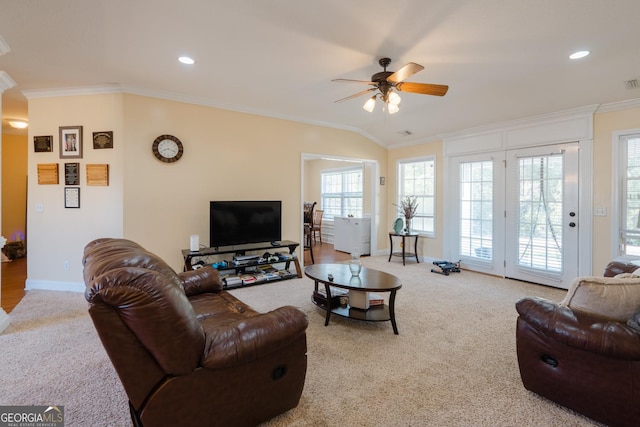 carpeted living room with crown molding and ceiling fan