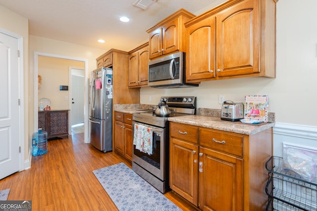 kitchen with appliances with stainless steel finishes and light wood-type flooring