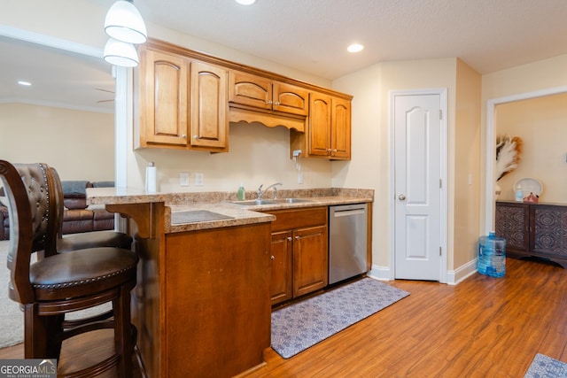 kitchen featuring stainless steel dishwasher, dark hardwood / wood-style floors, sink, and a breakfast bar area