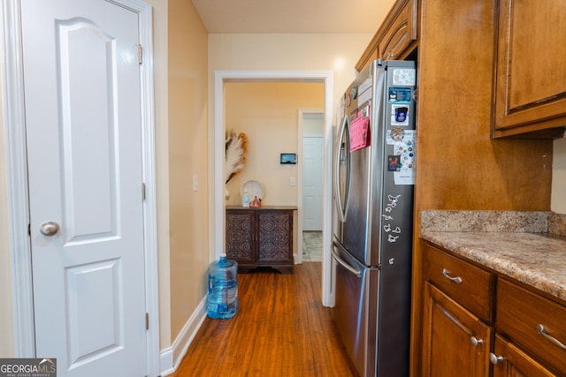 kitchen featuring stainless steel fridge and dark hardwood / wood-style flooring