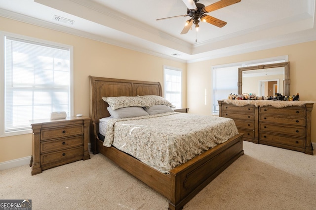 carpeted bedroom with crown molding, ceiling fan, and a tray ceiling