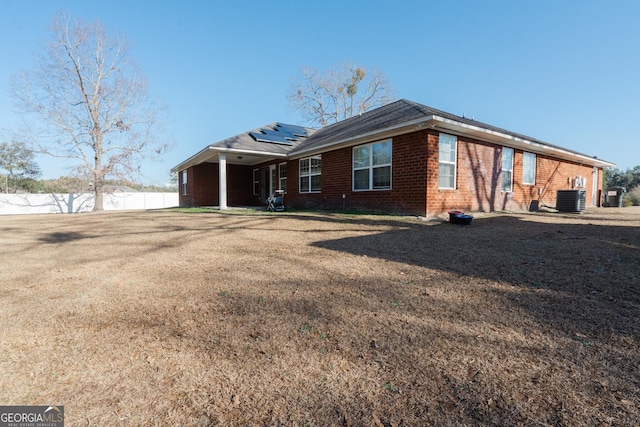 view of front of property with central AC and solar panels