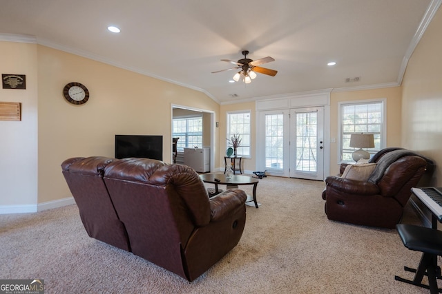 carpeted living room with ceiling fan, ornamental molding, and a wealth of natural light