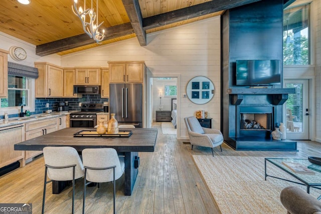 kitchen featuring butcher block countertops, wood ceiling, stainless steel appliances, light brown cabinetry, and decorative light fixtures