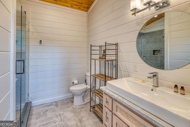 bathroom with vanity, a shower with door, toilet, and wood walls