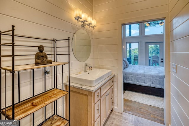 bathroom featuring vanity and wood walls