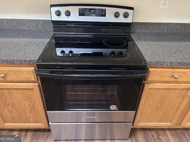 interior details with stainless steel range with electric stovetop and dark hardwood / wood-style floors