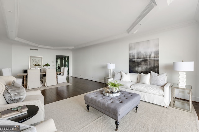 living area with ornamental molding, visible vents, baseboards, and wood finished floors