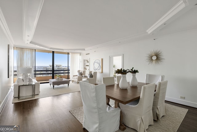 dining space with baseboards, wood finished floors, expansive windows, a tray ceiling, and crown molding