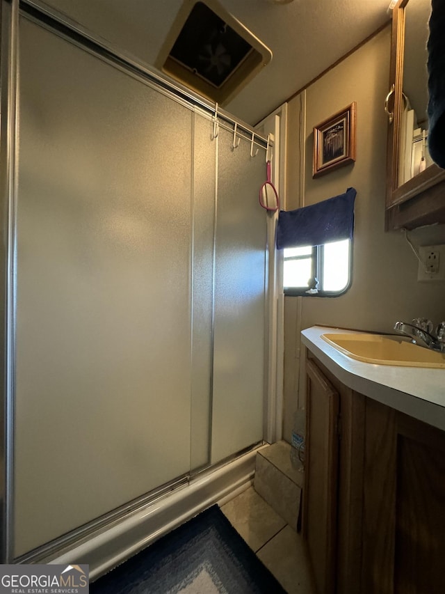 bathroom with tile patterned floors, an enclosed shower, and sink