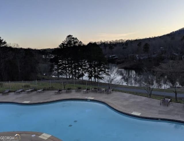 view of pool at dusk