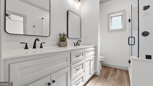 bathroom featuring vanity, wood-type flooring, toilet, and walk in shower