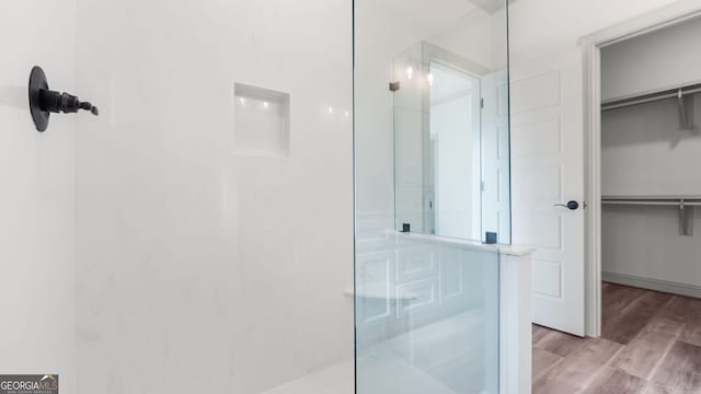 bathroom with wood-type flooring and a shower with door